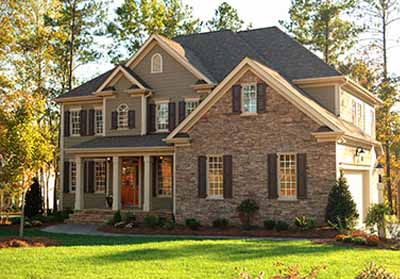 a large brick building with grass in front of a house